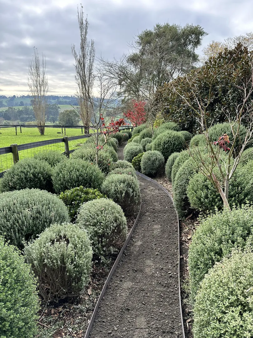 Garden path surrounded by lush greenery and scenic landscape.